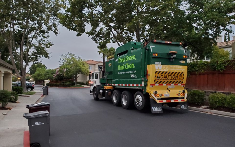 San Ramon, California, United States - August 29, 2019:  Garbage truck or recycling truck from Waste Management traveling through a suburban neighborhood in the morning, San Ramon, California, August 29, 2019.